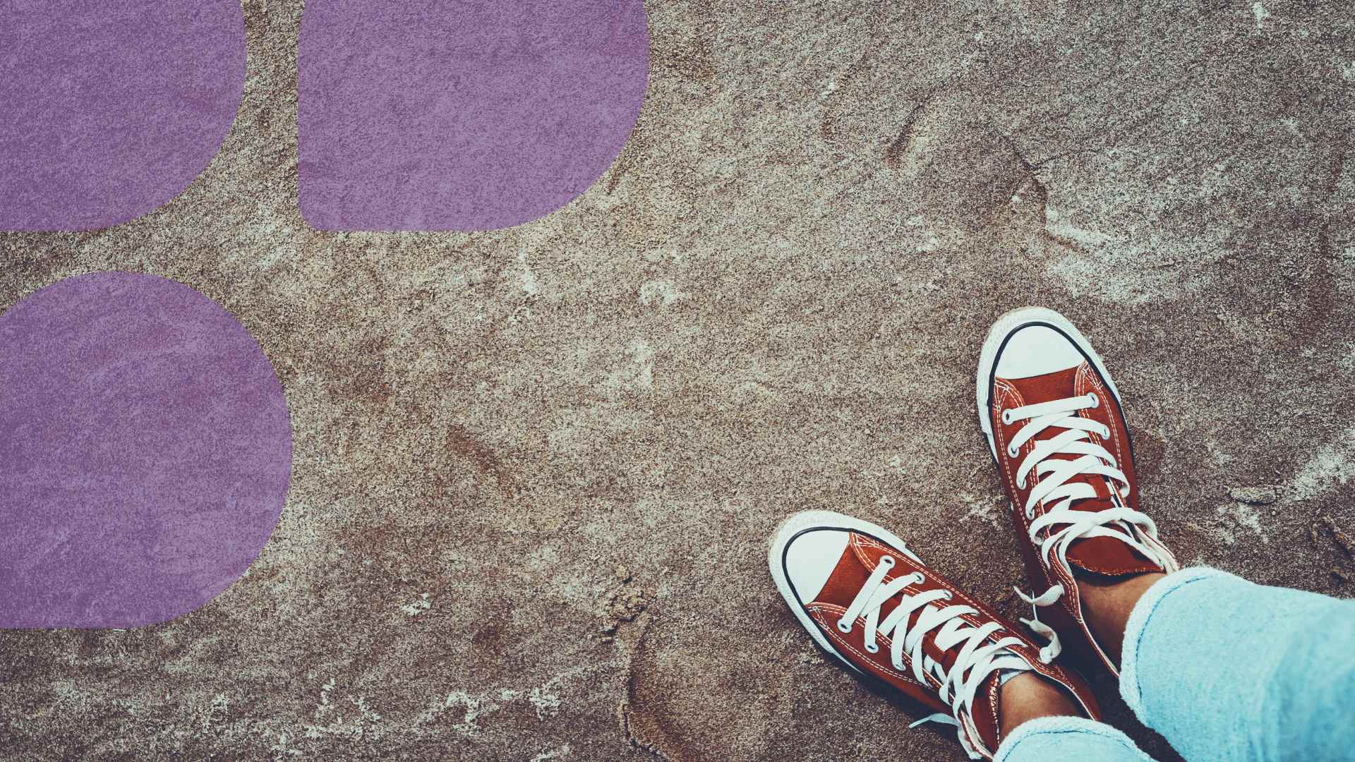 Ruskeanpunaiset tennarit pilkottavat kuvan reunasta. Toisessa reunassa läpikuultava violetteja pisaran muotoisia kuvaelementtejä.